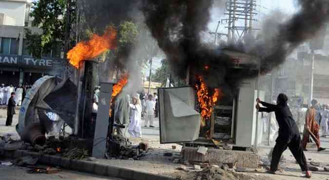 Manifestantes colocam fogo ao longo de ruas da cidade de Peshawar, no Paquisto (foto: A. MAJEED / AFP)