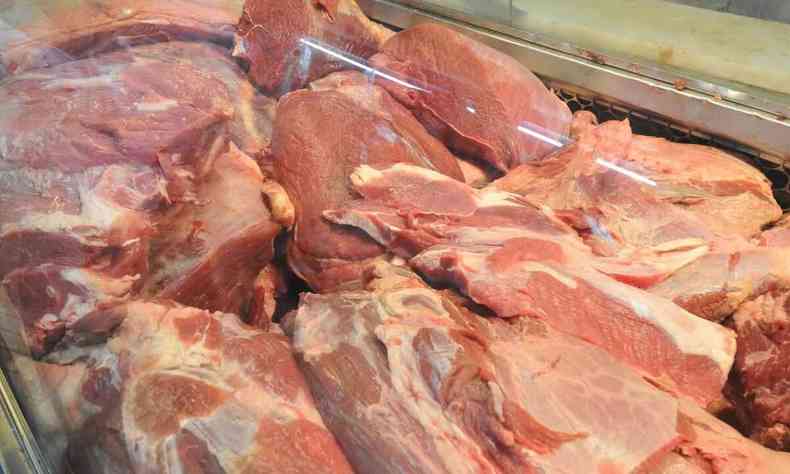 Carne bovina espalhada em prateleira de aougue.