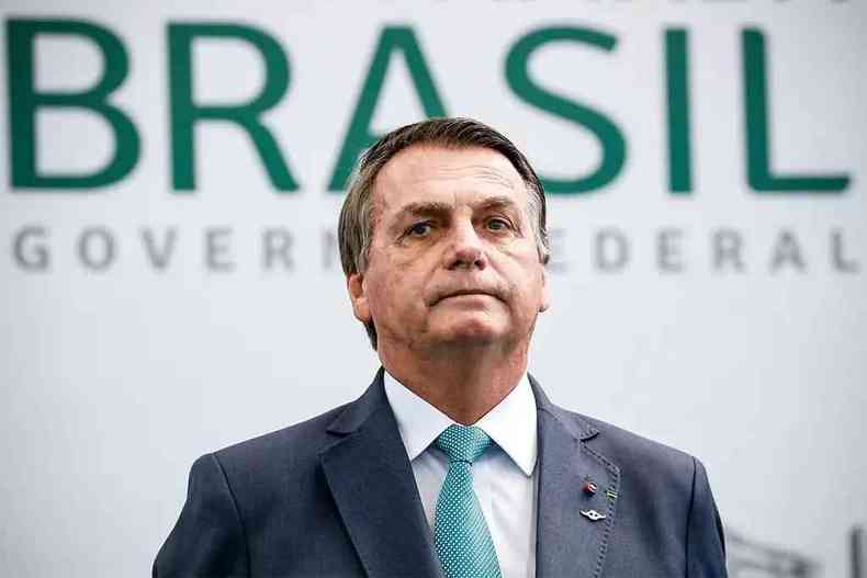 Jair Bolsonaro usa gravata azul e olha para frente