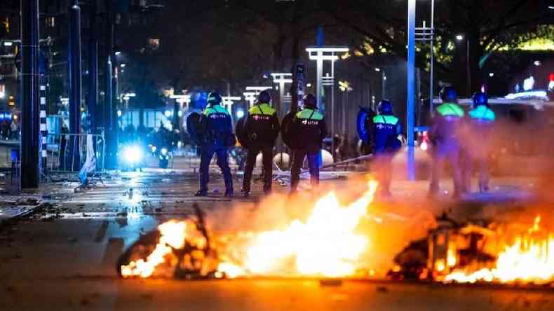 Policiais em frente a foco de incndio em rua europeia