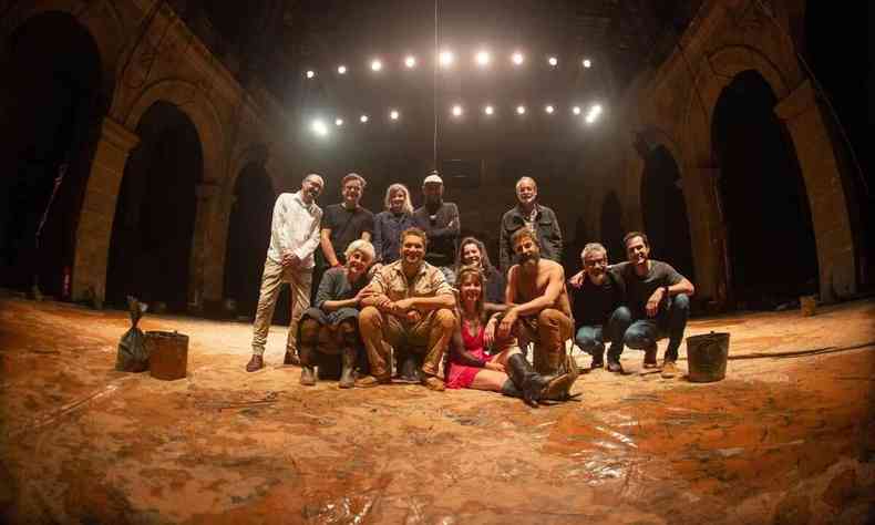 Foto de 12 integrantes da equipe da pea 'Tom na Fazenda' no palco, em Paris. No cho, esto espalhados quilos de areia e argila