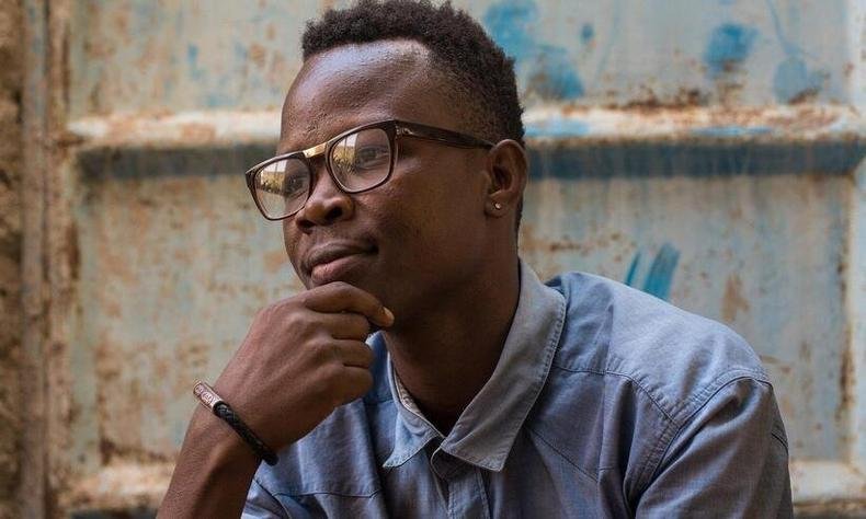 Jovem de �culos pensativo, com a m�o no queixo