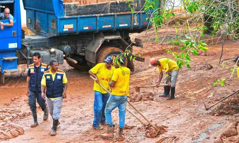 Trabalhadores retiram lama de rua de Sabara