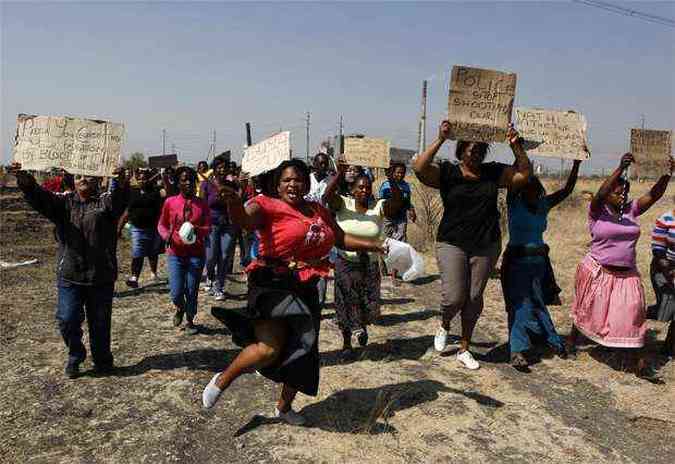 Mulheres carregam cartazes contra o massacre realizado pela polcia (foto: REUTERS/Siphiwe Sibeko)