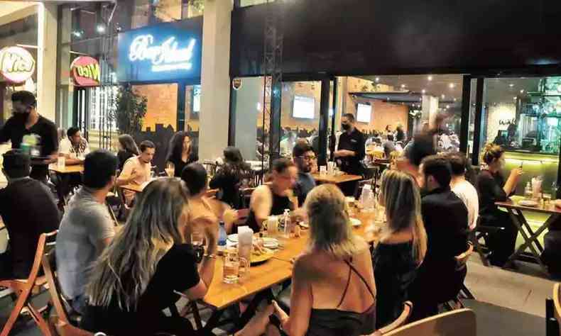 Na foto, pessoas sentadas em mesa de bar em Belo Horizonte