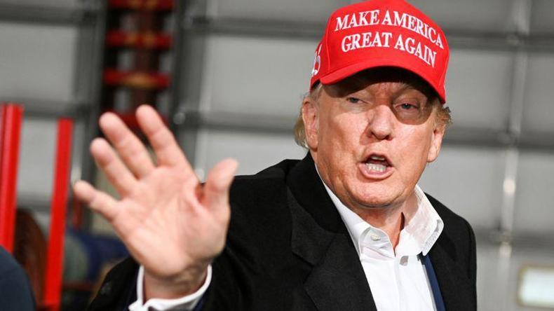 Trump com bon vermelho em que se l o slogan 'Make America Great Again'