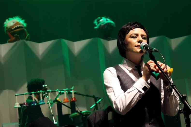 Vocalista Fernanda Takai, do Pato Fu, de camisa branca, gravata preta e colete cinza durante show no Palcio das Artes