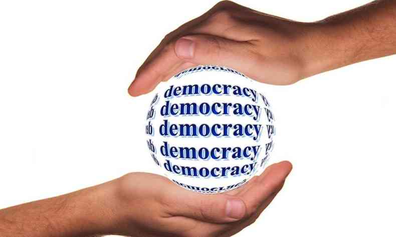 mos seguram uma bola formada pela palavra democracia em ingls: democracy