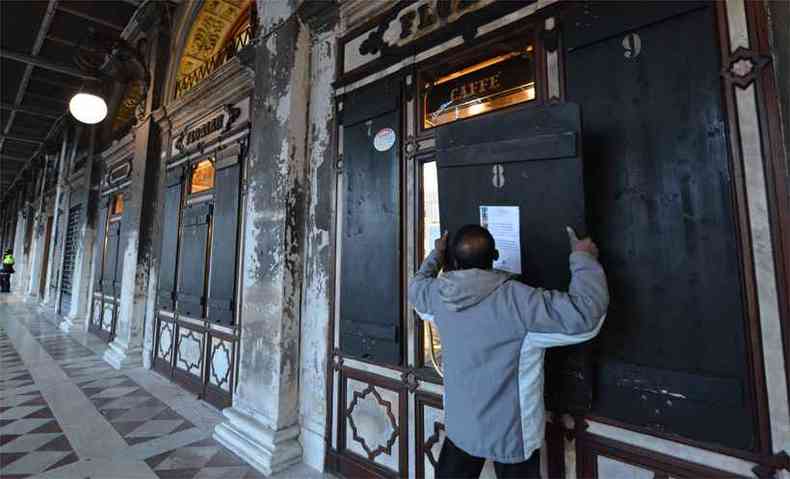 Comerciante fecha a janela de um caf , na Praa de So marcos, em Veneza, depois de o governo determinar quarentena na cidade e demais localidades do Norte da Itlia(foto: ANDREA PATTARO / AFP)