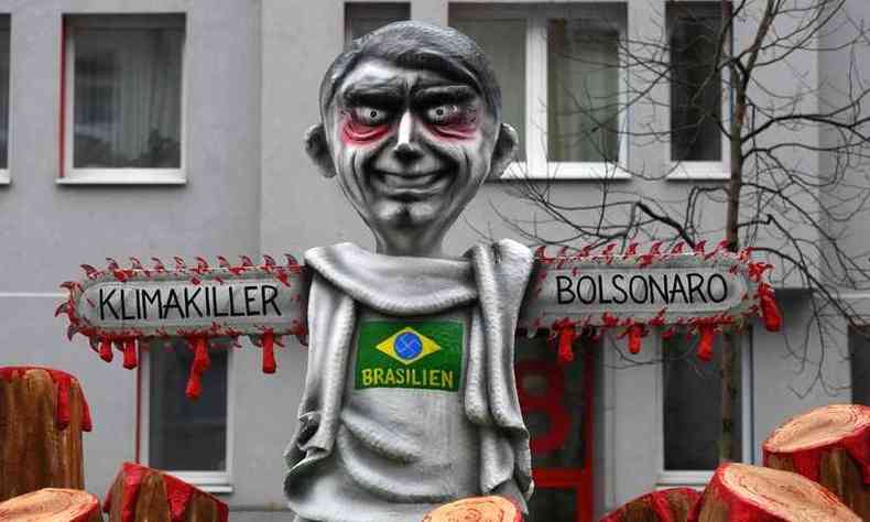No carnaval de Duesseldorf, na Alemanha, presidente Bolsonaro  retratado com braos de serra eltrica (foto: INA FASSBENDER /AFP )