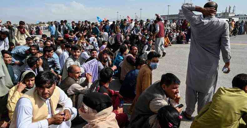 Afegos aguardam para deixar o aeroporto de Cabul, enquanto antigos aliados retiram ajuda aps domnio pelos Talibans(foto: Wakil Kohsar / AFP)