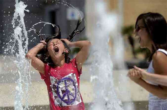 Turista se refresca da temperatura de mais de 40 graus em fonte de Roma (foto: AFP PHOTO / Filippo MONTEFORTE )