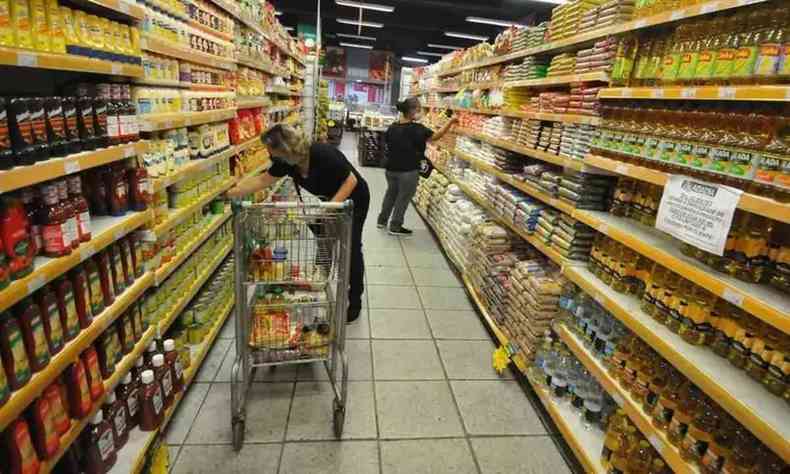 Na foto, pessoas compram em corredor de supermercado da Grande BH