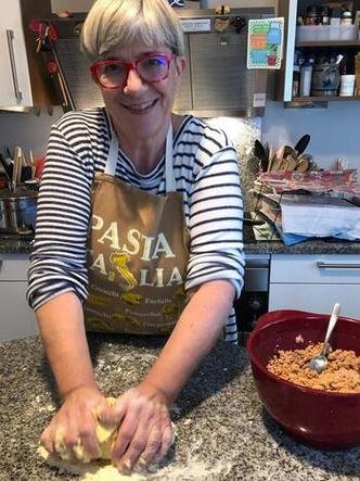 Nicole Krieger, embaixatriz de Luxemburgo no pa�s, olha para a c�mera sorrindo, enquanto amassa bolinho em uma cozinha