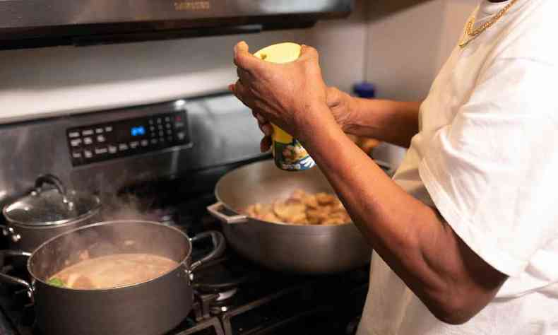 Mos de uma pessoa negra cozinhando 