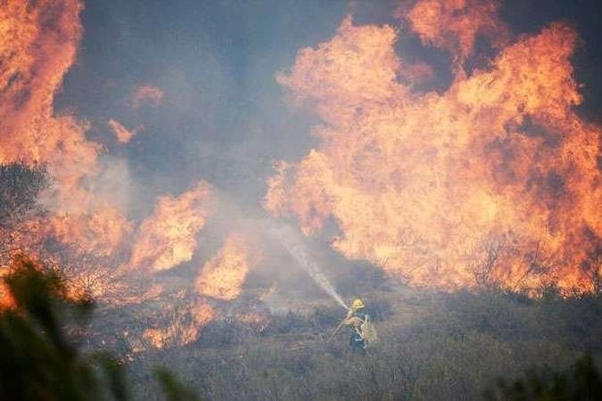 Incêndio iniciado na última quinta-feira forçou o fechamento de estrada costeira e de um campus universitário(foto: KEVORK DJANSEZIAN / GETTY IMAGES NORTH AMERICA / AFP) Incêndio iniciado na última quinta-feira forçou o fechamento de estrada costeira e de um campus universitário(foto: KEVORK DJANSEZIAN / GETTY IMAGES NORTH AMERICA / AFP)