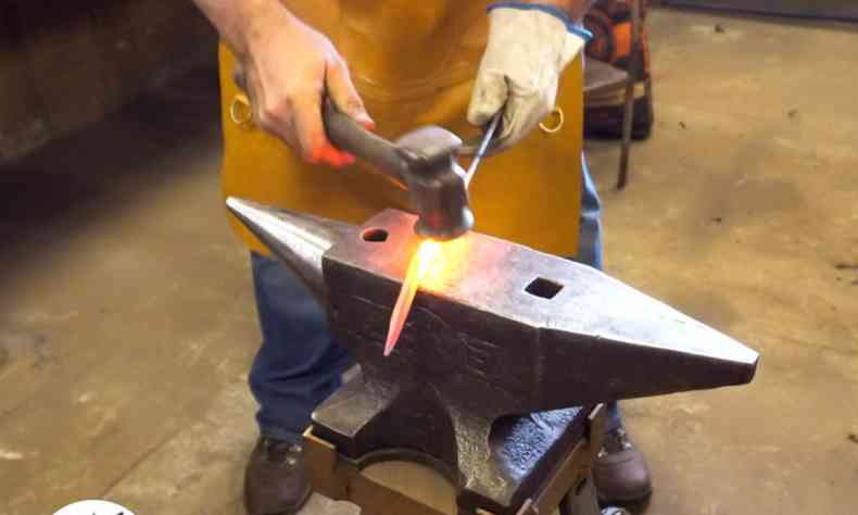 Homem forjando ferro quente 
