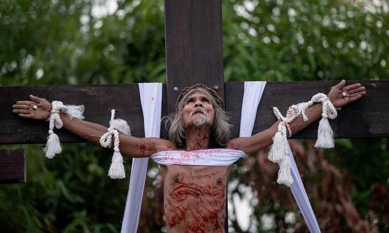  Os volunt�rios recebem pregos de oito cent�metros nas m�os e nos p�s. Em seguida, um grupo de homens vestidos de romanos levanta a cruz para que o p�blico os veja crucificados(foto: AFP / Noel CELIS )
