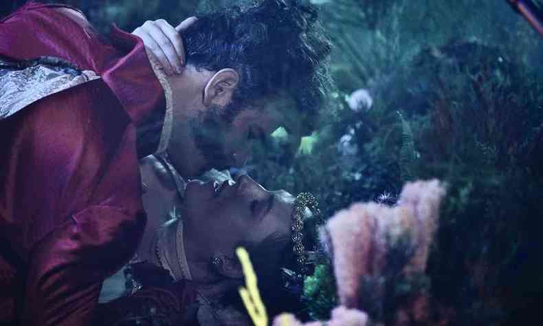 Deitados, o ator Daniel de Oliveira, caracterizado como Pedro I, e a atriz Louisa Sexton, como Dona Leopoldina, se beijam na boca