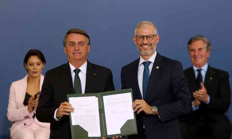 Jair Bolsonaro mostrando um documento ao lado de Victor Godoy