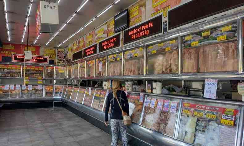 Imagem mostra cliente olhando carnes em um aougue