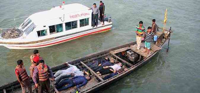 Corpos das vítimas da tragédia são transportados em um pequeno barco. Acidentes de balsa são frequentes em Bangladesh.(foto: AFP Photo)