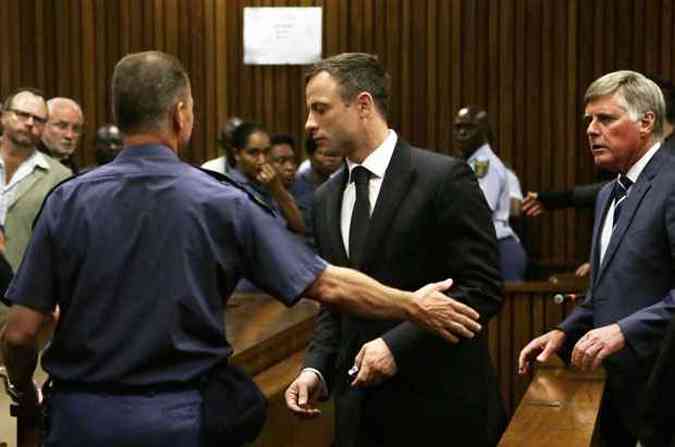 Atleta paralmpico Oscar Pistorius  levado por policiais aps o julgamento(foto: Themba Hadebe/AFP Photo)