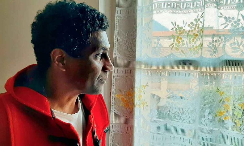 Escritor Edimilson Almeida Pereira, de lado, olha atravs do vidro de uma janela 