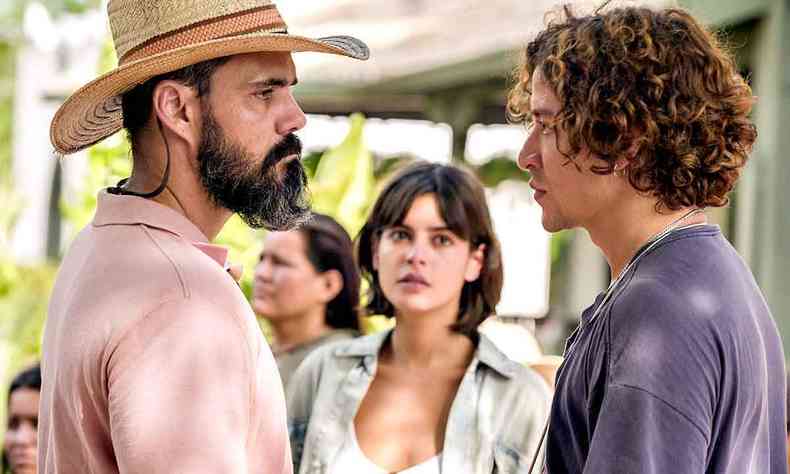 Juliano Cazarré olha para Jesuíta Barbosa, ao fundo está a atriz Julia Dalavia, em cena de da novela Pantanal
