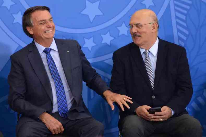 Bolsonaro ri e cola a mão na perna de Ribeiro