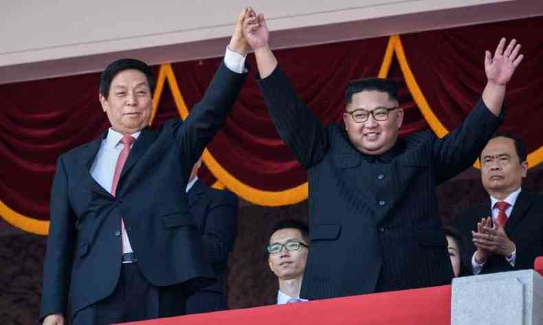 Kim Jong-un preferiu mostrar sua amizade com a China, levantando a mo do enviado do presidente Xi Jinping(foto: AFP / Ed JONES)