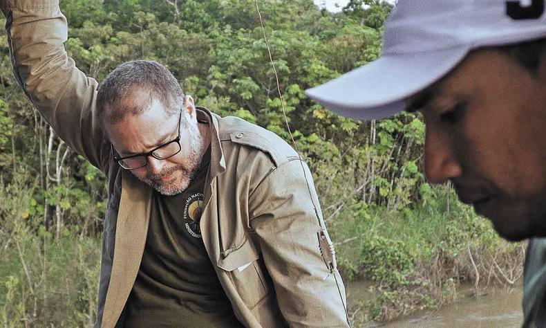 O indigenista Bruno Pereira est de cabea baixa, recostado em uma rvore, em cena do documentrio A inveno do outro