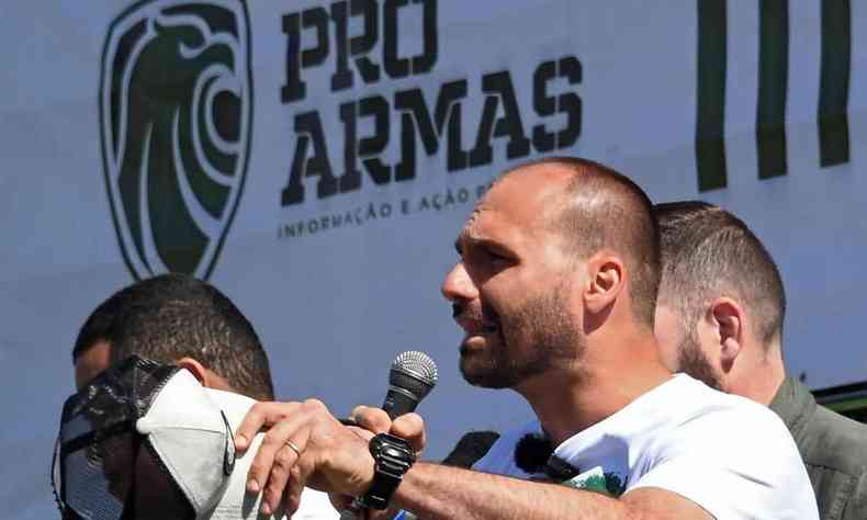 Eduardo Bolsonaro discursa; ao fundo um painel escrito Pr-armas