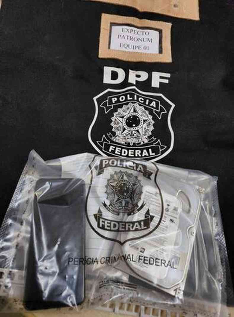 materiais apreendidos em um plstico transparente sobre um pano com a logo da polcia federal 