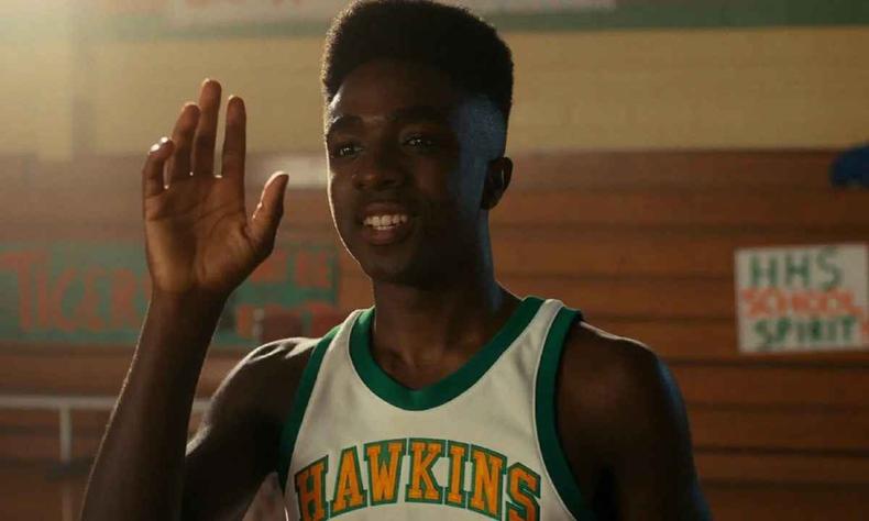 Caleb McLaughlin em cena de Stanger Things usando uniforme de basquete