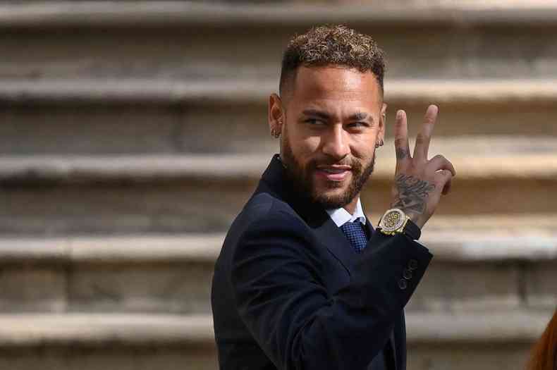 Neymar faz sinal com a mo direita e sorri
