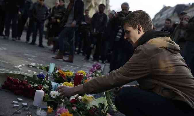 Um homem acende uma vela em memorial pelas vítimas do atentado terrorista em Bruxelas(foto: KENZO TRIBOUILLARD / AFP)