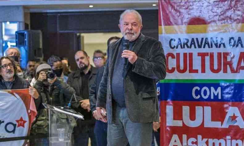 Lula, segurando microfone, fala em evento com lideranas culturais em Porto Alegre. Ao fundo l-se 'Caravana da Cultura com Lula e Alckmin'