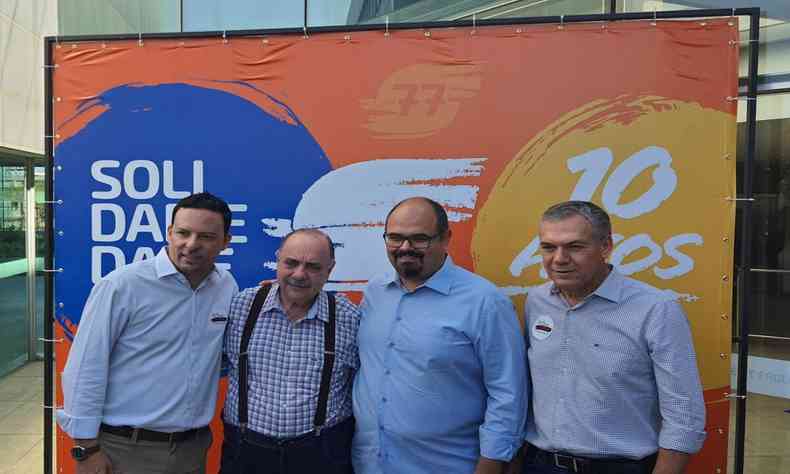 Wendel Mesquita, Fuad Noman, Mateus Simes e Z Silva em p, na frente de um banner dos dez anos do partido Solidariedade