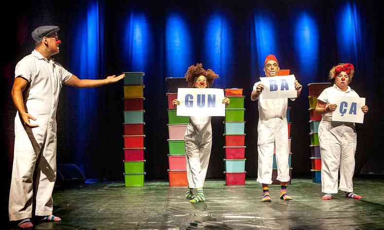 Durante o espetáculo Bagunça, quatro atores do grupo Roda Gigante estão no palco, segurando cartazes que formam a palavra gunbaça 