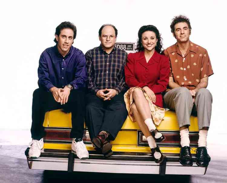 Jerry, George, Elaine e Kramer sentados em um carro amarelo 