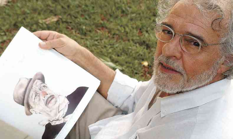 O artista grfico Elifas Andreato olha para a cmera, segurando caricatura de Adoniran Barbosa com nariz vermelho de palhao