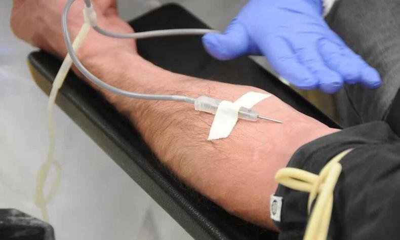 Agulha injetada no bra�o colhendo o sangue 