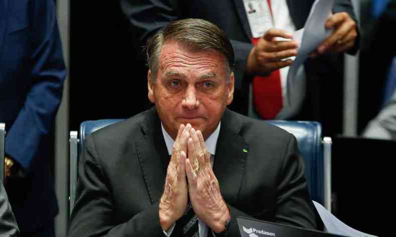 Jair Bolsonaro com mos no rosto