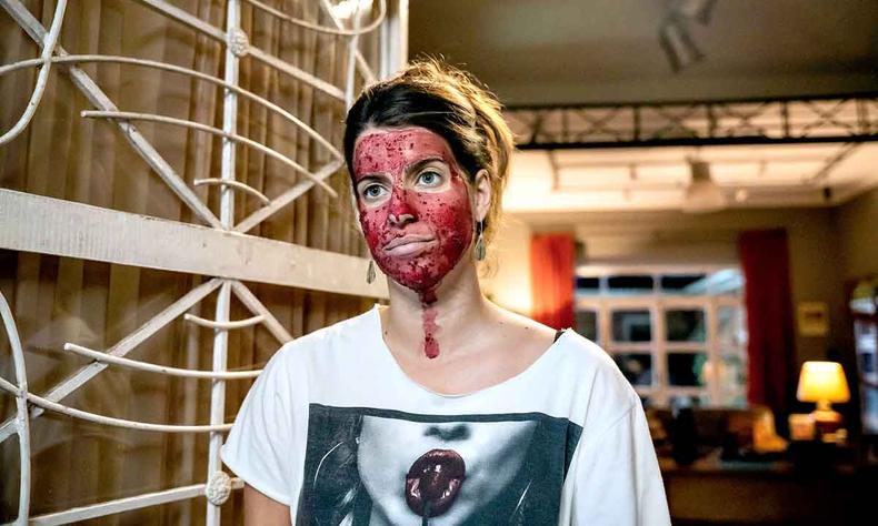 A atriz Maria Bopp vive na série uma blogueira da vida saudável que ela define como 'gratiluz-goodvibes-vegana'(foto: Paramount+/divulgação) A atriz Maria Bopp com o rosto coberto de tinta vermelha e camiseta que mostra lábios femininos em cena da série As seguidoras
