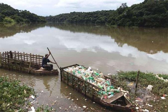 Homem empurra lixo pescado do rio Tiet em Santana do Parnaba, a 32 quilmetros de So Paulo(foto: REUTERS/Paulo Whitaker)