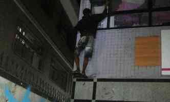 Foto mostra o homem saindo da loja pela janela aps ser encontrado pela PM(foto: PMMG/Divulgao)
