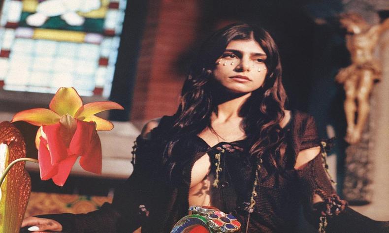 A modelo fez postagens em apoio aos ataques do grupo Hamas a Israel(foto: Reprodução/Redes Sociais) Mia em um local com figura religiosa de jesus ao fundo e orquídea em primeiro plano
