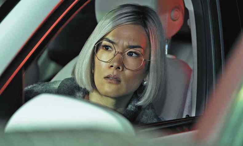 Atriz Alii Wong, da janela do carro, tem semblante preocupado durante cena da srie Treta 