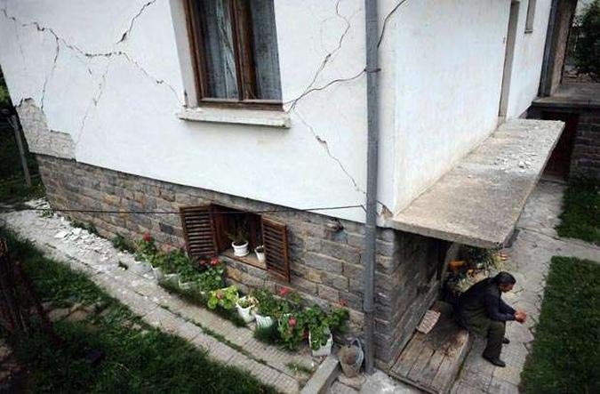 Homem descansa do lado de fora de uma casa que ficou danificada com o terremoto (foto: AFP PHOTO / NIKOLAY DOYCHINOV)